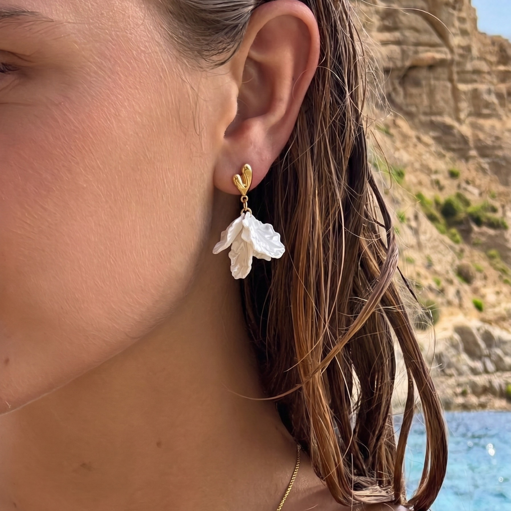 Pendientes de botón dorados con colgantes de flores blancas